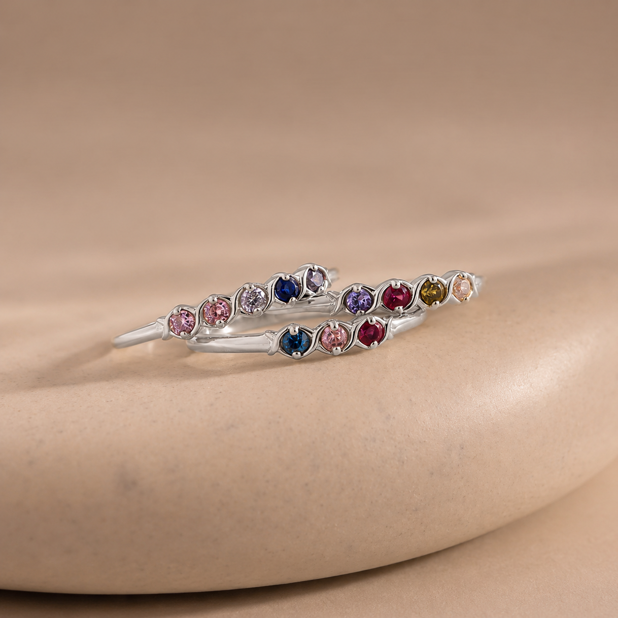 Silver bracelet with multicolored gemstones on a beige surface